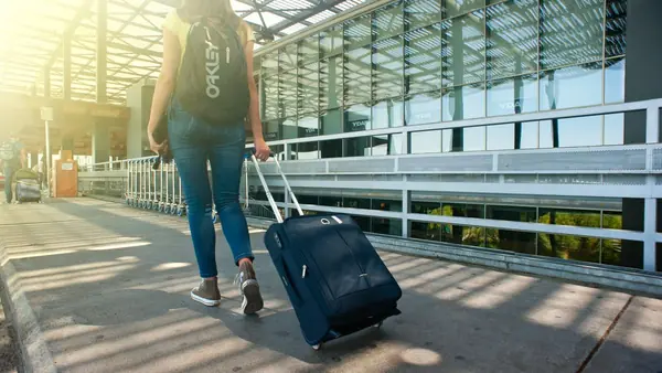 Traveller pulling a suitcase outside an airport terminal