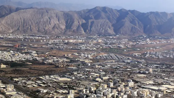 منظر جوي لمدينة مسقط وخلفها جبال الحجر