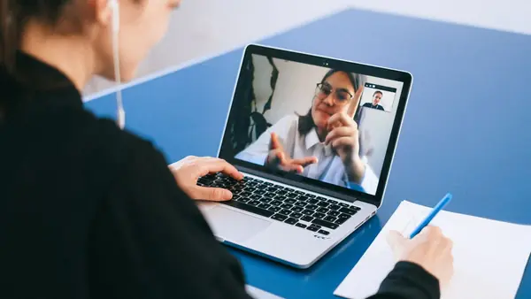 Woman on a video call with a colleague on her laptop